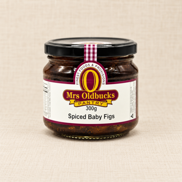 Mrs Oldbucks Pantry Spiced Baby Figs 300g jar on a warm beige linen background.