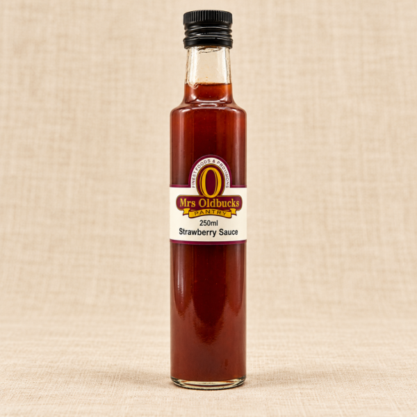 Mrs Oldbucks Pantry Strawberry Sauce 250 ml glass bottle with a black screw cap on a warm beige linen background.