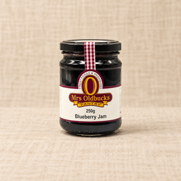 Mrs Oldbucks Pantry Blueberry Jam 250g jar on a warm beige linen background