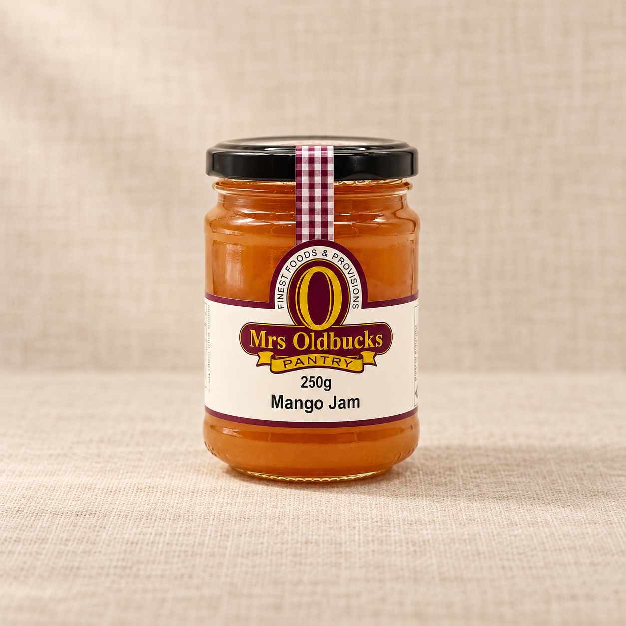 Mrs Oldbucks Pantry Mango Jam 250g jar on a warm beige linen background