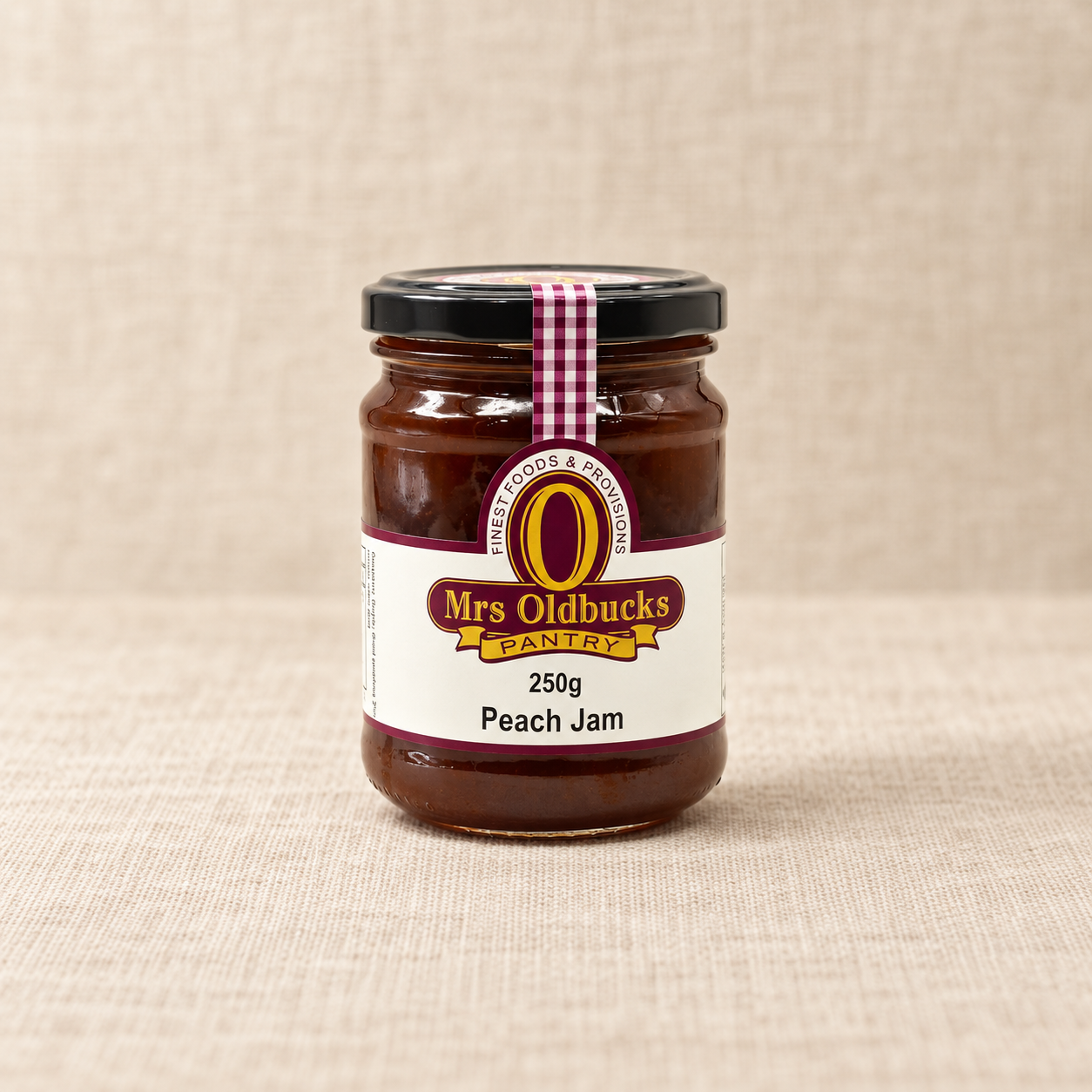 Mrs Oldbucks Pantry Peach Jam 250g jar on a warm beige linen background