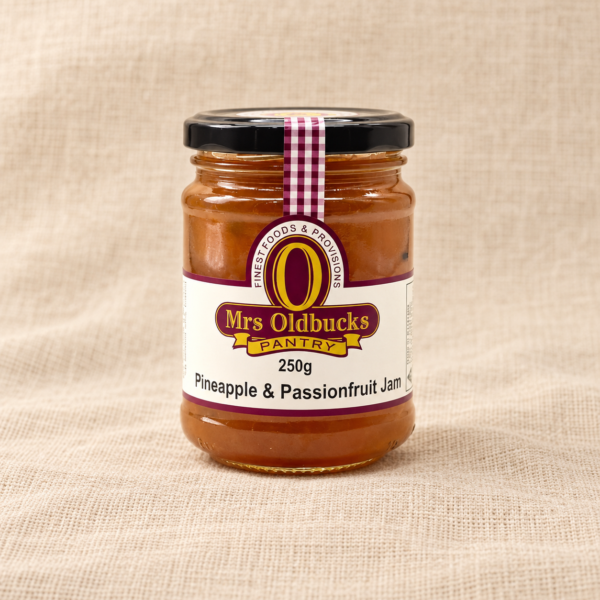 Mrs Oldbucks Pantry Pineapple and Passionfruit Jam 250g jar on a warm beige linen background