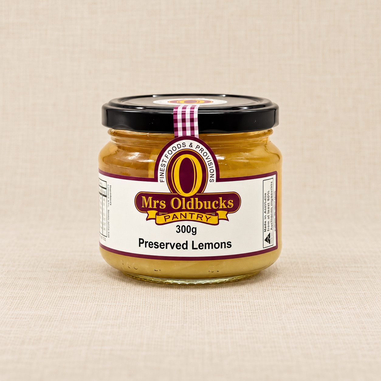 Mrs Oldbucks Pantry Preserved Lemons 300g jar on a warm beige linen background.