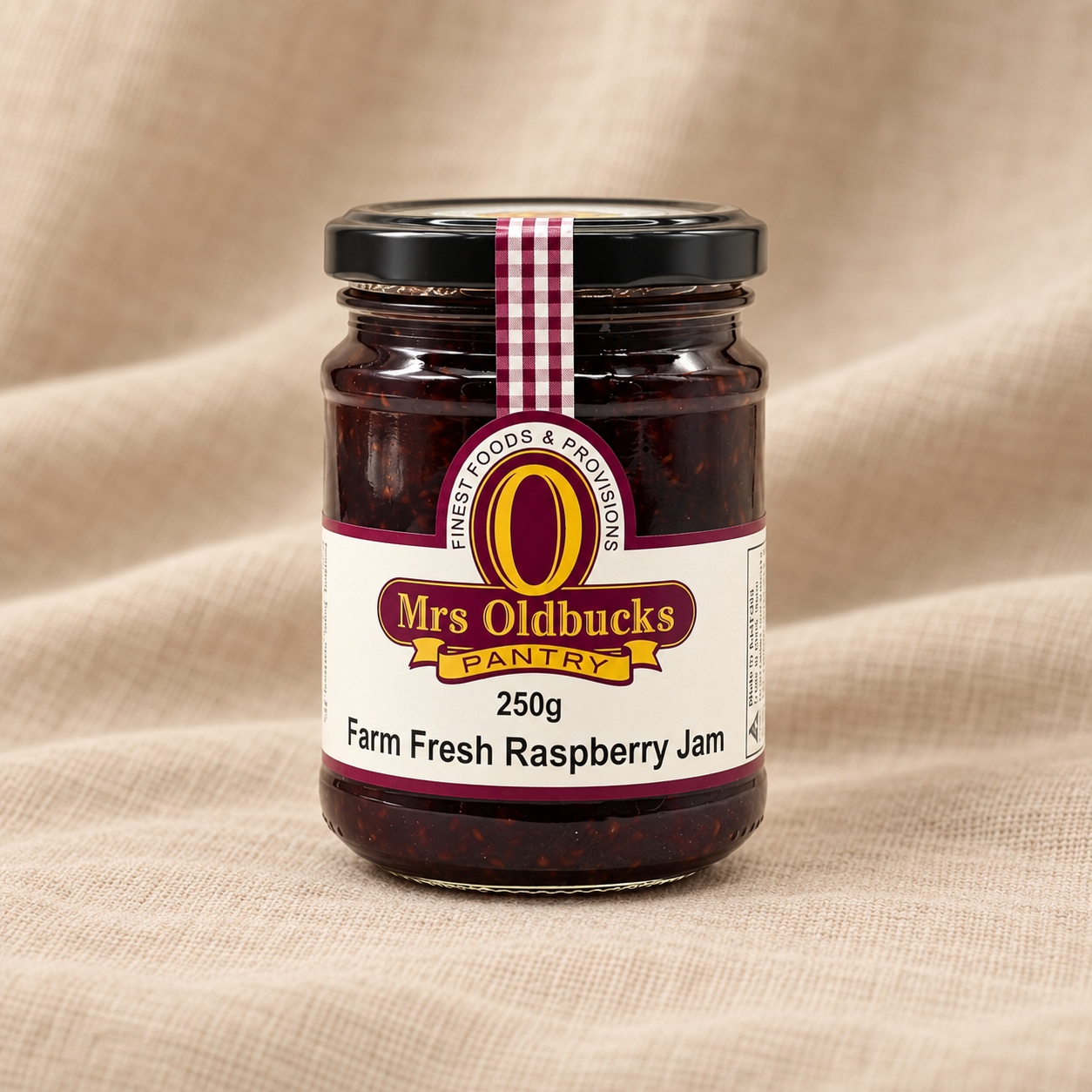 Mrs Oldbucks Pantry Farm Fresh Raspberry Jam 250g jar on a warm beige linen background