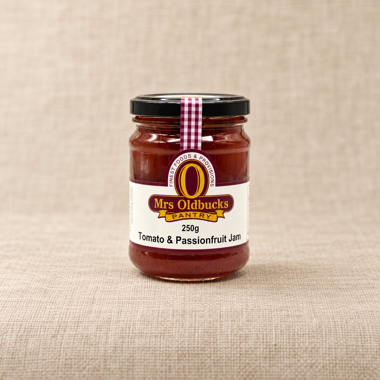 Mrs Oldbucks Pantry Tomato and Passionfruit Jam 250g jar on a warm beige linen background