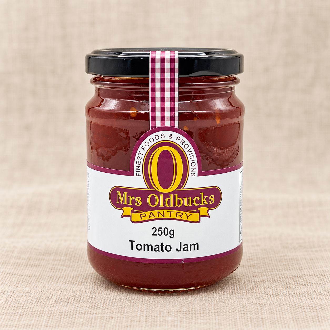 Mrs Oldbucks Pantry Tomato Jam 250g jar on a warm beige linen background