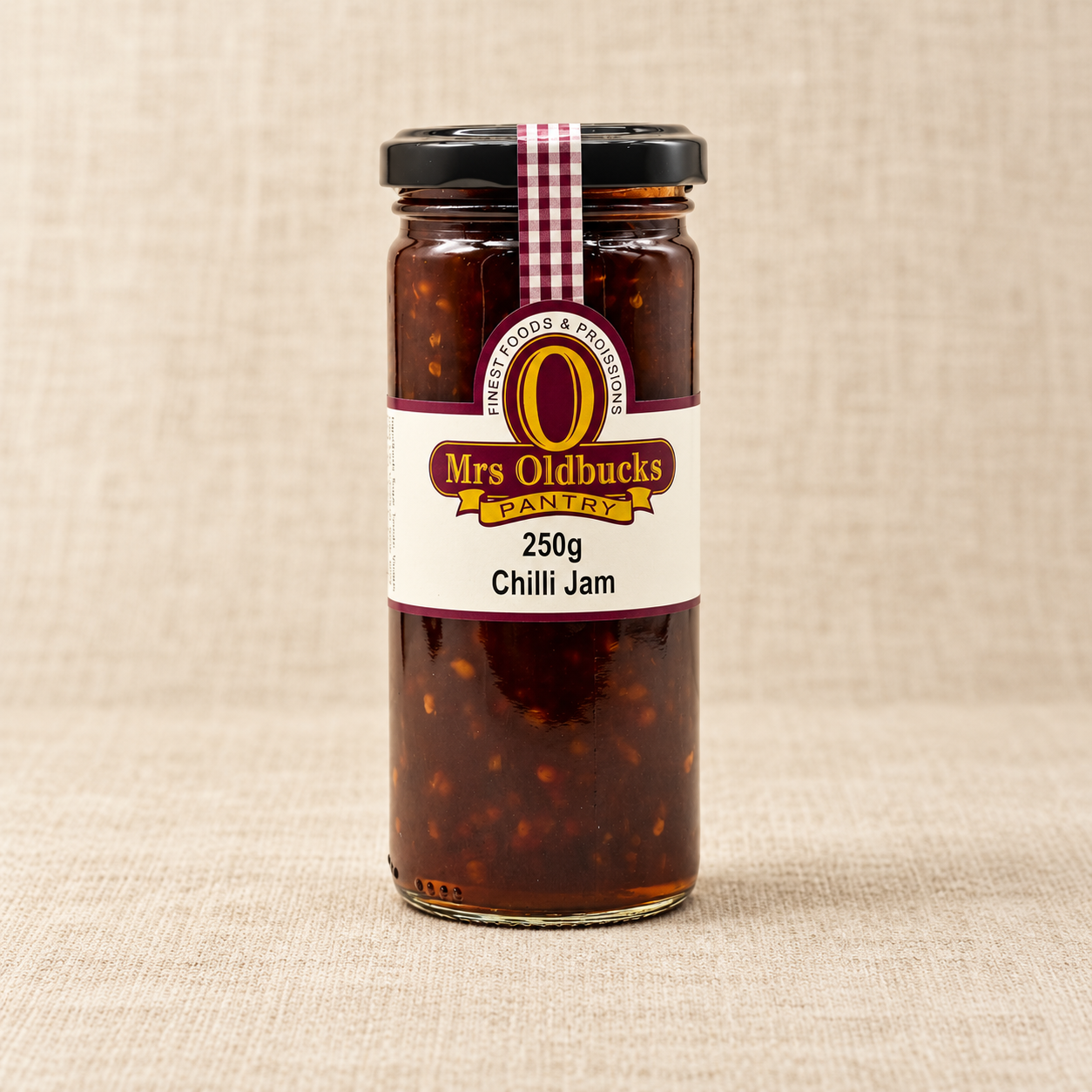 Mrs Oldbucks Pantry Chilli Jam 250g jar on a warm beige linen background