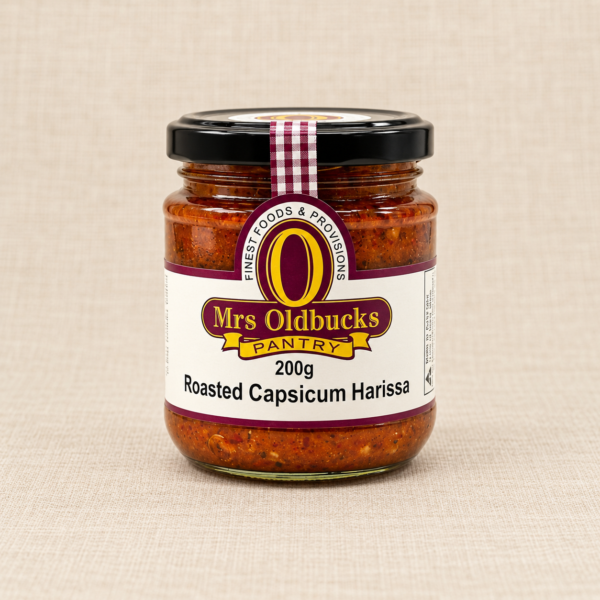 Mrs Oldbucks Pantry Roasted Capsicum Harissa 200g jar on a warm beige linen background.