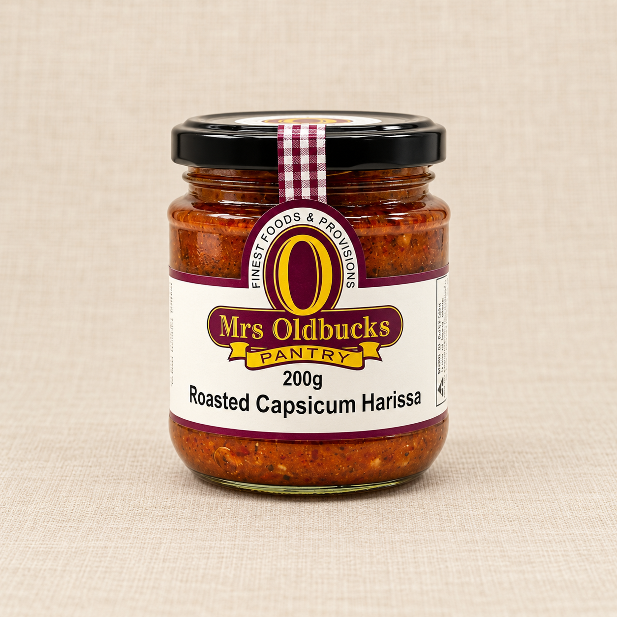 Mrs Oldbucks Pantry Roasted Capsicum Harissa 200g jar on a warm beige linen background.