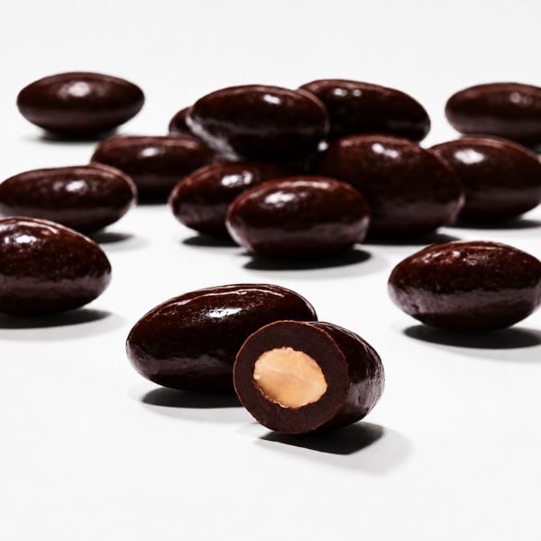 Glossy dark chocolate-coated almonds arranged on a clean white background, featuring one almond cut open to reveal the roasted almond centre. Elegant studio-style product photograph in a square WooCommerce format.