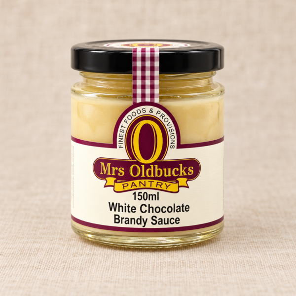Mrs Oldbucks Pantry White Chocolate Brandy Sauce 150 ml glass jar with a black lid on a warm beige linen background.
