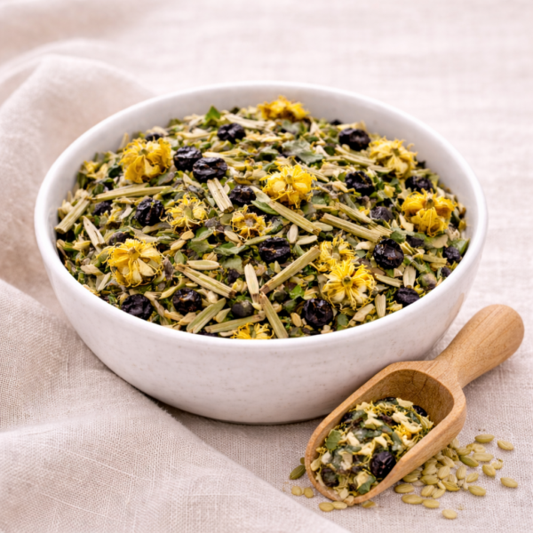 Mrs Oldbucks Pantry Bloom And Breathe Herbal Blend Bloom & Breathe loose leaf herbal tea with elderberries, mint and mullein flowers in a white ceramic bowl with wooden scoop on linen.