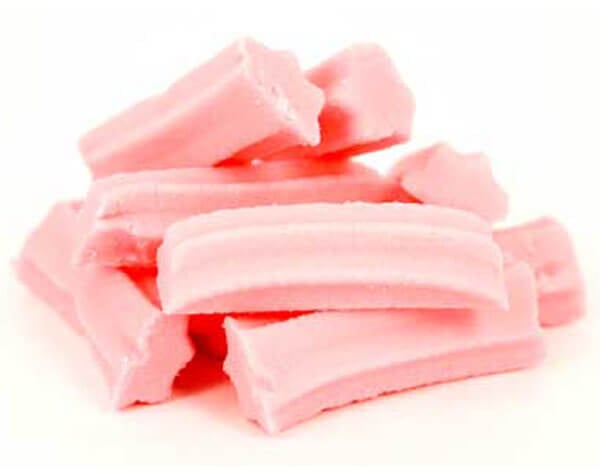 Mrs Oldbucks Pantry Mini Musk Sticks Mini pink musk sticks stacked in soft natural light, showing their smooth texture and nostalgic confectionery style