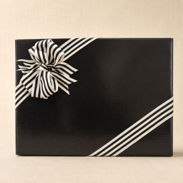 Black bespoke hamper gift box finished with black-and-ivory striped ribbon on a soft linen background